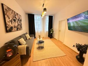 a living room with a couch and a flat screen tv at Stage One City in Andernach