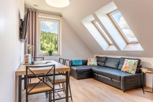 a living room with a couch and a table at Apartamenty Zieleniec in Duszniki Zdrój