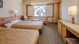 a hotel room with two beds and a window at Madarao Kogen Hotel in Iiyama