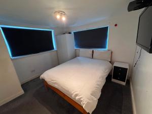 a small bedroom with a bed and two windows at Mallow View Hotel in Cleethorpes +73 photos