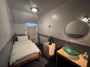 a bathroom with a bed and a sink and a mirror at Mallow View Hotel in Cleethorpes