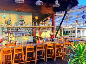 a bar with wooden chairs and a counter with bottles at Sunset Beach Hotel - Adults Only in Haad Rin