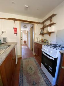 a kitchen with a stove and a counter top at Glen Villa - 3 bedroom house - Stroud town centre in Stroud