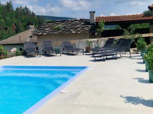 a patio with chairs and a swimming pool at Къщи за гости "Зелената долина" in Dŭlbok Dol