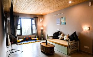 a living room with a couch and a table at Lofted Peaks in Pālampur