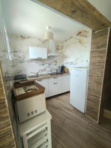 a kitchen with a white refrigerator and white cabinets at Mimosas - villa in Fréjus