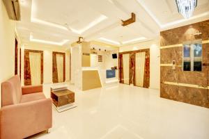 a living room with a couch and a chair in a room at HOTEL O DIVIRA INN in Dhanbād