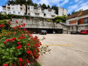 a parking lot with red flowers in front of a building at Hotel Oaza in Konjic
