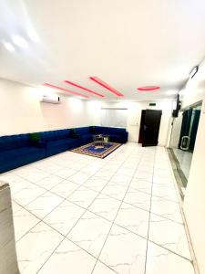 a room with a blue couch and a white tile floor at شاليهات زارا 1 in Taif