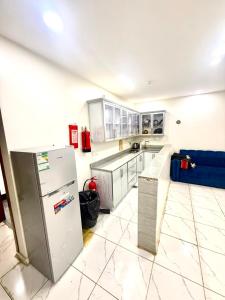 a kitchen with a refrigerator and a tile floor at شاليهات زارا 1 in Taif +2 photos