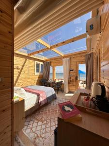 a bedroom with a bed and a view of the ocean at Sondos Camp in Nuweiba‘ el Muzeinah