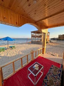 a beach with an umbrella and a chair on the beach at Sondos Camp in Nuweiba‘ el Muzeinah