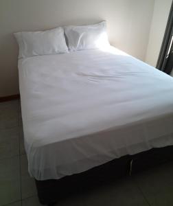 a large white bed with white sheets and pillows at M's guest place Nata in Nata