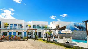 a resort with a swimming pool and a building at Sonho Nosso in Maragogi