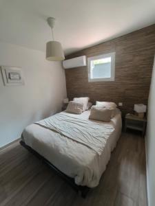 a bedroom with a large bed with two pillows at Mimosas - villa in Fréjus +9 photos