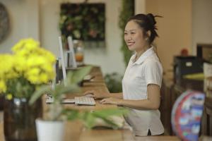 a woman sitting at a desk with a laptop computer at Sunset Beach Hotel - Adults Only in Haad Rin