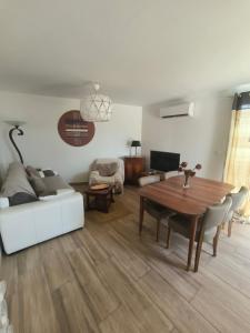 a living room with a table and a couch at Mimosas - villa in Fréjus