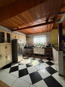 a kitchen with a black and white checkered floor at Casa verde in Santo Antônio do Pinhal