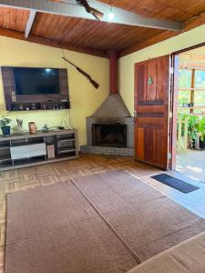 a living room with a fireplace and a tv at Casa verde in Santo Antônio do Pinhal +1 photo