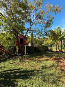 a yard with a red bird house and trees at Casa verde in Santo Antônio do Pinhal