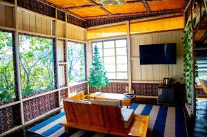 a living room with a couch and a tv at Santorini by Busybee Lake Cabins in Mwanza