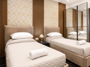 a bedroom with two beds and a mirror at Azure Gold Apartment in Senglea