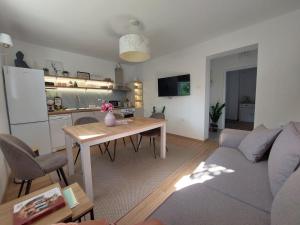 a living room with a couch and a table and a kitchen at Secret Garden House in Surduk