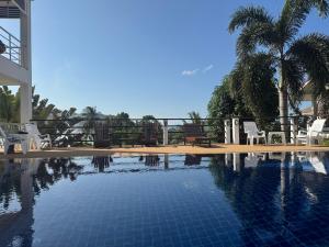 ein Schwimmbecken mit Stühlen und einer Palme in der Unterkunft BRW Samui in Bophut 