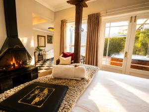 a bedroom with a king sized bed with a fireplace at Goblin's Creek in St. Helena Bay +67 photos