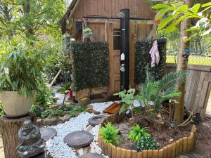 a garden with a statue and plants in front of a building at Relax Wald Apartment mit optional Buchung Sauna und Whirlpool in Neustadt am Rübenberge +39 photos