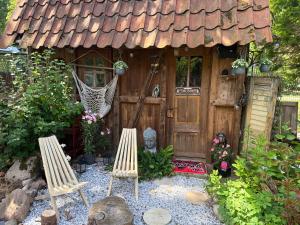 a small house with two chairs in front of it at Relax Wald Apartment mit optional Buchung Sauna und Whirlpool in Neustadt am Rübenberge