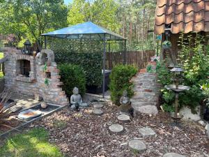 a garden with a brick fireplace and a gazebo at Relax Wald Apartment mit optional Buchung Sauna und Whirlpool in Neustadt am Rübenberge