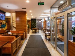 a restaurant with wooden tables and chairs and a restaurant with tables at Hotel Oaza in Konjic