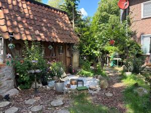 a garden in front of a house with a fire pit at Relax Wald Apartment mit optional Buchung Sauna und Whirlpool in Neustadt am Rübenberge