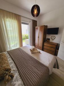a bedroom with a large bed and a window at Sol Greco Apartment in Skala Rachoniou