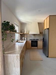 a kitchen with a stainless steel refrigerator and wooden cabinets at Villa Ljeto in Pupnatska Luka