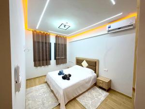 a bedroom with a bed with a teddy bear on it at Palm & Tide Kenitra Residence in Kenitra
