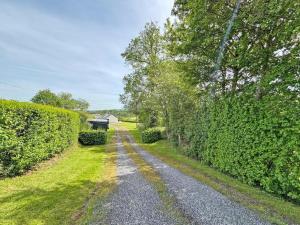 a path through a hedge with a house in the distance at Beacons Cottage-Uk36406 in Bronllys