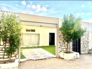 a house with a garage and two trees at شاليهات زارا 1 in Taif