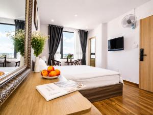 a hotel room with a bed and a bowl of fruit on a table at Laimeront Dalat Hotel & Apartment in Da Lat