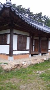 寶城郡的住宿－韓國傳統房屋- 春諾達恩酒店，田野上带木门和窗户的建筑