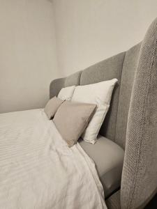 a bed with white sheets and pillows in a room at Rynek Staromiejski Apartment in Koszalin