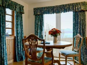 a dining room with a table and chairs and a window at Fearnmore Church in Fearnmore
