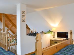a bedroom with a bed and a staircase with a television at Fearnmore Church in Fearnmore