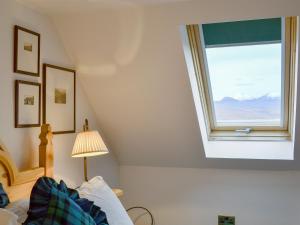 a bedroom with a window and a bed and a lamp at Fearnmore Church in Fearnmore