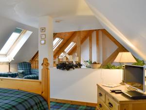 a bedroom with a bed and a desk with a television at Fearnmore Church in Fearnmore +15 photos