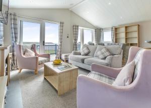 a living room with a couch and chairs and a table at Lower Hyde in Shanklin