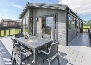 a tiny house with a table and chairs on a deck at Lower Hyde in Shanklin