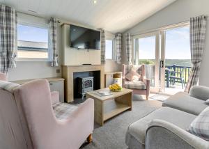 a living room with a couch and chairs and a fireplace at Lower Hyde in Shanklin