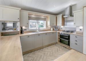 a kitchen with white cabinets and a sink at Lower Hyde in Shanklin +61 photos